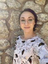 photo of a woman in front of a rock background wearing a shirt with ravens on it